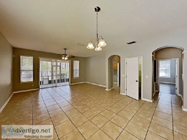 The fenced backyard has a screened patio