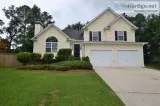 The home has a spacious outdoor living area with a wooden deck