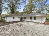 With a large yard mature trees and a cheerful-painted front door