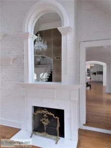 White Fireplace Mantel With Beautiful Arched Mirror